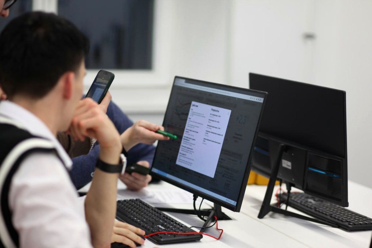 A team focused together on data on a screen