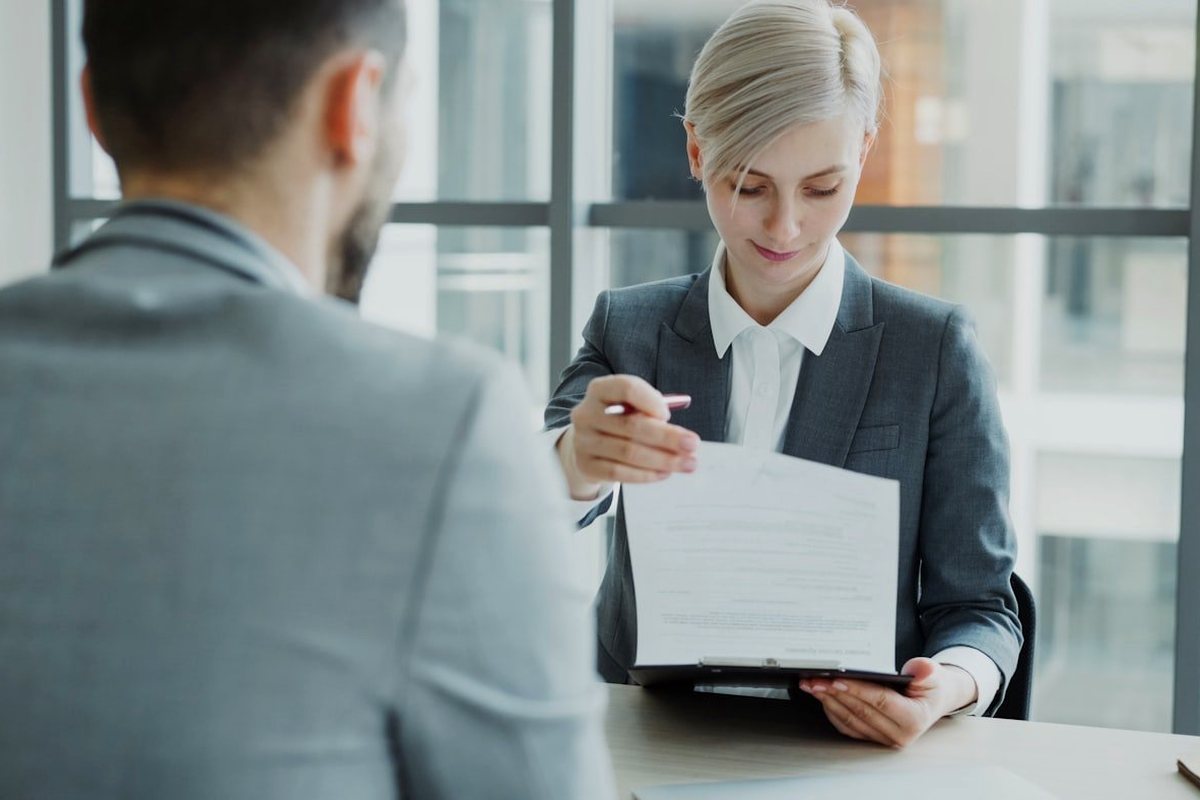 A legal adviser walking a client through a document at a desk